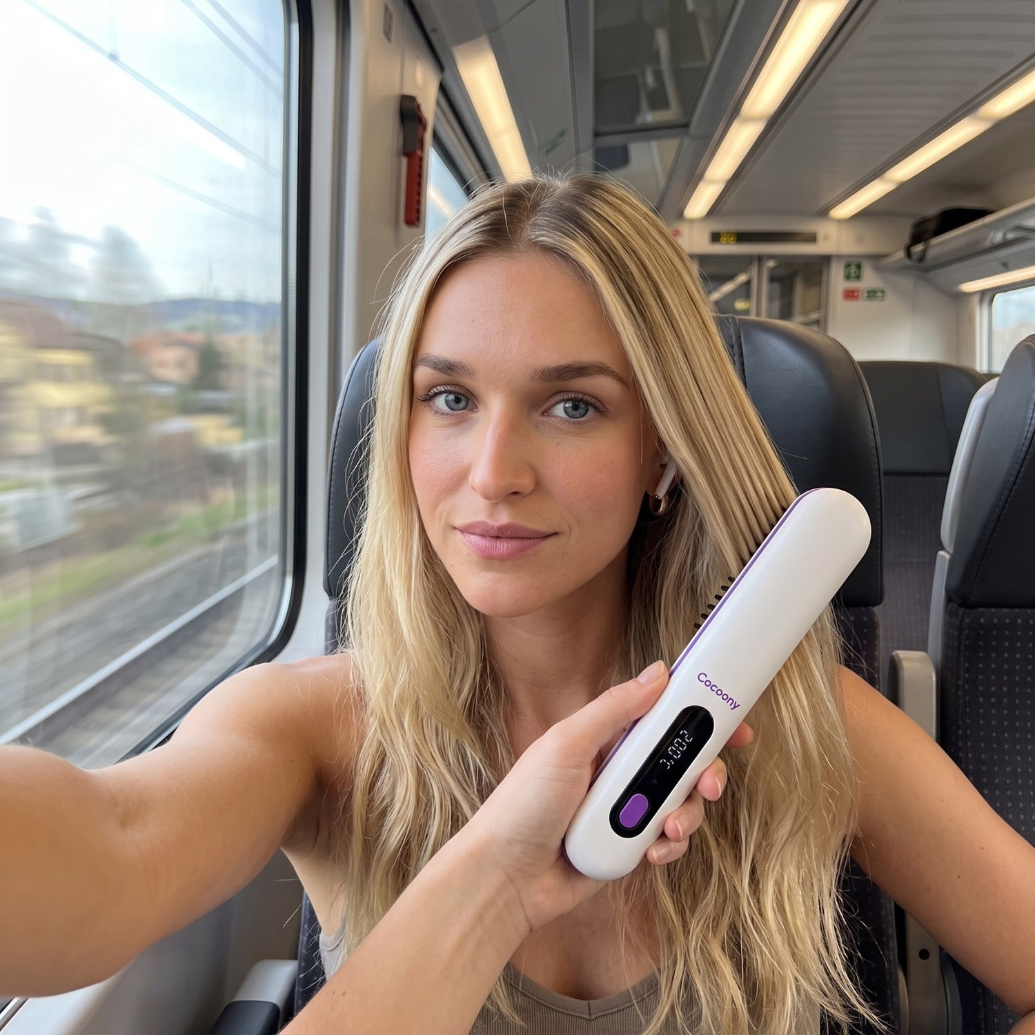 Straightening her hair on the train with the cordless Cocoony brush